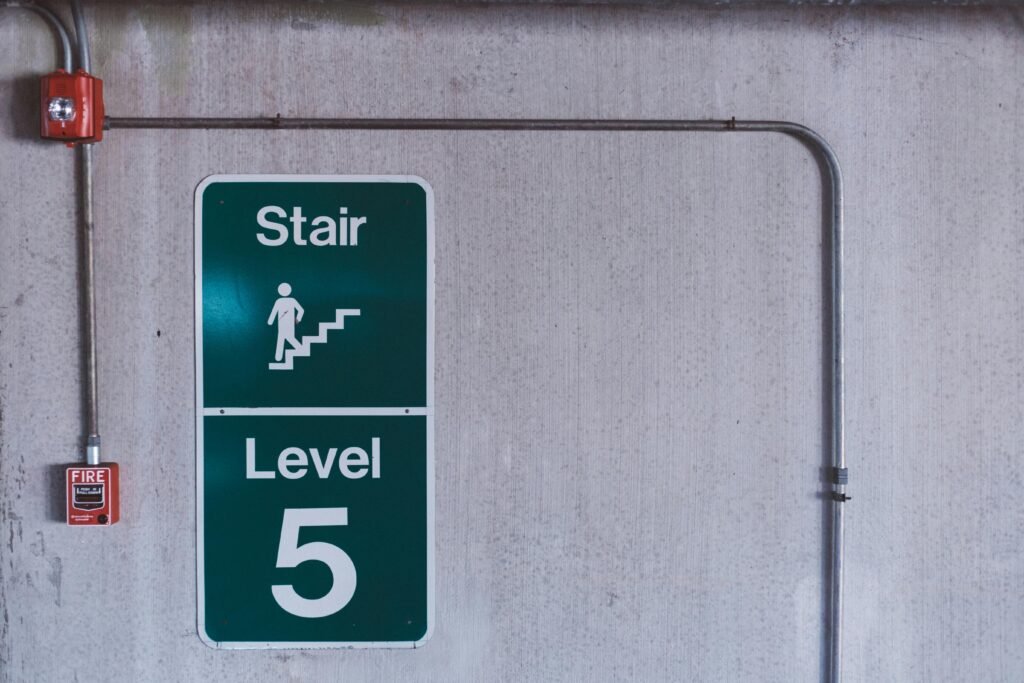 A fire alarm and stair sign on level 5 in an industrial indoor setting.